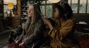 Movie still from “Children of Men” (2006), directed by Alfonso Cuarón – Two women sitting in a room one is brushing the other's hair; Close Up shot, Over the shoulder angle