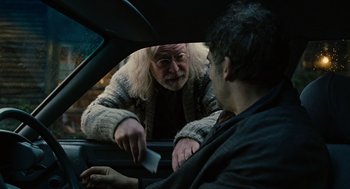 Movie still from “Children of Men” (2006), directed by Alfonso Cuarón – A man in the back seat of a car looking at another man in the back seat of a car; Medium shot, Over the shoulder angle