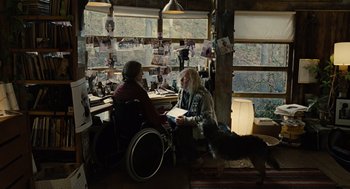 Movie still from “Children of Men” (2006), directed by Alfonso Cuarón – A man in a wheel chair talking to an older man in a wheelchair in front of a window; Wide shot, Over the shoulder angle