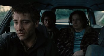 Movie still from “Children of Men” (2006), directed by Alfonso Cuarón – A group of people sitting in the back of a car; Close Up shot, Over the shoulder angle
