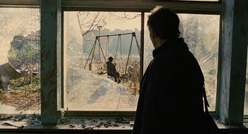 Movie still from “Children of Men” (2006), directed by Alfonso Cuarón – A man looking out of a window at a swing set; Wide shot, Over the shoulder angle