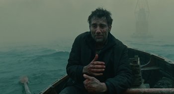 Movie still from “Children of Men” (2006), directed by Alfonso Cuarón – A man sitting on a boat in the water; Medium shot, Low angle