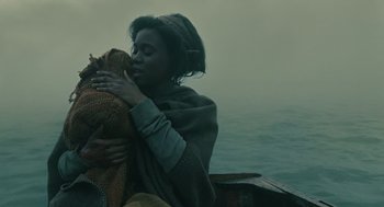 Movie still from “Children of Men” (2006), directed by Alfonso Cuarón – A woman is holding a stuffed animal while sitting in a boat; Close Up shot, Low angle