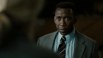 Movie still from “True Detective” (2014), created by Issa López – A person wearing a suit and tie; Close Up shot, Over the shoulder angle