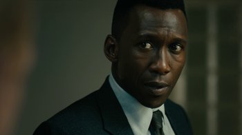 Movie still from “True Detective” (2014), created by Issa López – A person wearing a suit and tie; Close Up shot, Over the shoulder angle