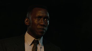 Movie still from “True Detective” (2014), created by Issa López – A man wearing a suit and tie in the dark; Close Up shot, Over the shoulder angle