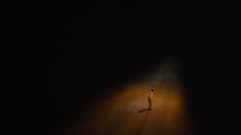 Movie still from “True Detective” (2014), created by Issa López – A man standing in the middle of a dark street; Extreme Wide shot, High angle