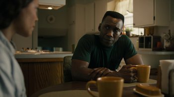 Movie still from “True Detective” (2014), created by Issa López – A man sitting at a table with a cup of coffee in front of him; Close Up shot, Over the shoulder angle