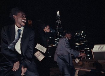 Movie still from “Sam Akpro - Death By Entertainment” (2023), directed by Pedro Takahashi – Medium shot, Low angle