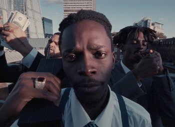 Movie still from “Sam Akpro - Death By Entertainment” (2023), directed by Pedro Takahashi – Close Up shot, Low angle