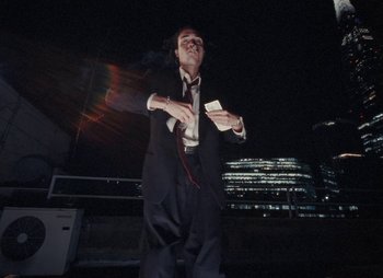 Movie still from “Sam Akpro - Death By Entertainment” (2023), directed by Pedro Takahashi – Medium shot, Low angle