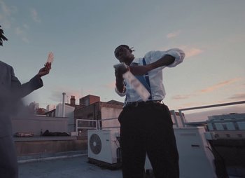 Movie still from “Sam Akpro - Death By Entertainment” (2023), directed by Pedro Takahashi – Medium shot, Low angle