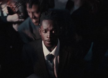 Movie still from “Sam Akpro - Death By Entertainment” (2023), directed by Pedro Takahashi – Close Up shot, High angle