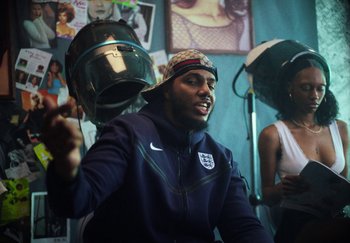 Movie still from “AJ Tracey - Bubble Bath” (2024), directed by Late Milk – Medium shot, Low angle