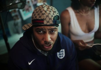 Movie still from “AJ Tracey - Bubble Bath” (2024), directed by Late Milk – Close Up shot, Over the shoulder angle