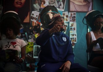 Movie still from “AJ Tracey - Bubble Bath” (2024), directed by Late Milk – Medium shot, Over the shoulder angle