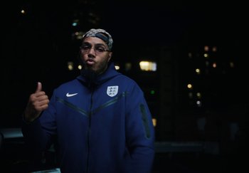 Movie still from “AJ Tracey - Bubble Bath” (2024), directed by Late Milk – Medium shot, Low angle