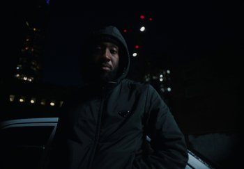 Movie still from “AJ Tracey - Bubble Bath” (2024), directed by Late Milk – Close Up shot, Low angle