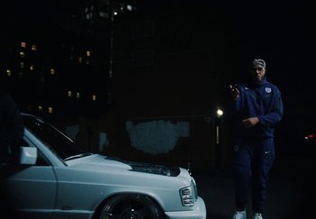 Movie still from “AJ Tracey - Bubble Bath” (2024), directed by Late Milk – Medium shot, Low angle