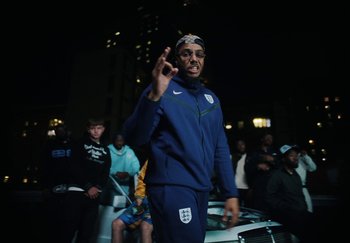 Movie still from “AJ Tracey - Bubble Bath” (2024), directed by Late Milk – Medium shot, Low angle