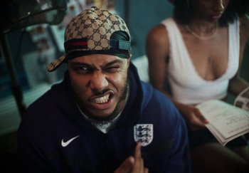 Movie still from “AJ Tracey - Bubble Bath” (2024), directed by Late Milk – Close Up shot, Low angle