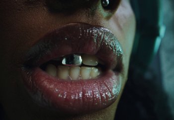 Movie still from “AJ Tracey - Bubble Bath” (2024), directed by Late Milk – Extreme Close Up shot, Overhead angle