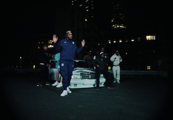 Movie still from “AJ Tracey - Bubble Bath” (2024), directed by Late Milk – Wide shot, Low angle