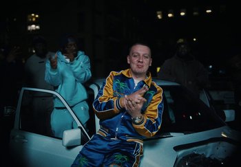 Movie still from “AJ Tracey - Bubble Bath” (2024), directed by Late Milk – Medium shot, Low angle