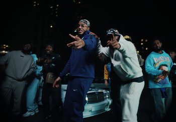 Movie still from “AJ Tracey - Bubble Bath” (2024), directed by Late Milk – Medium shot, Low angle