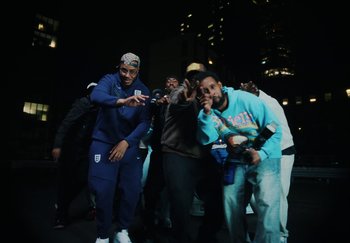 Movie still from “AJ Tracey - Bubble Bath” (2024), directed by Late Milk – Medium shot, Low angle