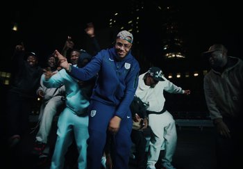 Movie still from “AJ Tracey - Bubble Bath” (2024), directed by Late Milk – Medium shot, Over the shoulder angle