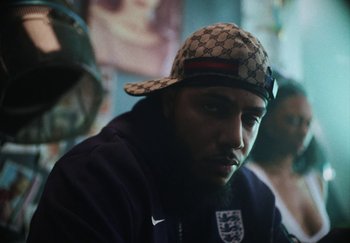 Movie still from “AJ Tracey - Bubble Bath” (2024), directed by Late Milk – Close Up shot, Low angle