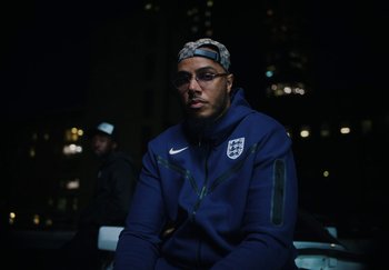 Movie still from “AJ Tracey - Bubble Bath” (2024), directed by Late Milk – Close Up shot, Low angle