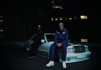 Movie still from “AJ Tracey - Bubble Bath” (2024), directed by Late Milk – Wide shot, Low angle