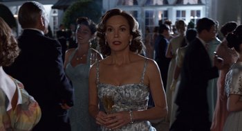 Movie still from “Trumbo” (2015), directed by Jay Roach – A woman in a blue dress walking in a crowd of people; Medium shot, Over the shoulder angle