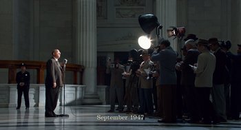 Movie still from “Trumbo” (2015), directed by Jay Roach – A group of men standing around a microphone; Wide shot, Low angle