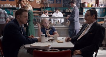 Movie still from “Trumbo” (2015), directed by Jay Roach – A group of people sitting at a table in a restaurant; Medium shot, Over the shoulder angle