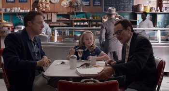 Movie still from “Trumbo” (2015), directed by Jay Roach – A group of people sitting at a table in a restaurant; Medium shot, Over the shoulder angle