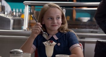 Movie still from “Trumbo” (2015), directed by Jay Roach – A young girl holding a spoon in front of a bowl of ice cream; Close Up shot, Over the shoulder angle