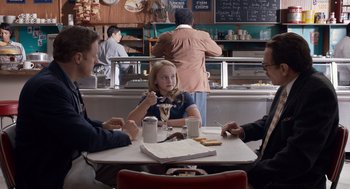 Movie still from “Trumbo” (2015), directed by Jay Roach – A group of people sitting at a table in a restaurant; Medium shot, Over the shoulder angle