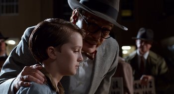 Movie still from “Trumbo” (2015), directed by Jay Roach – An older man and a young boy are looking at each other; Close Up shot, Over the shoulder angle