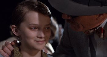 Movie still from “Trumbo” (2015), directed by Jay Roach – A young boy smiling at the camera with an older man; Close Up shot, Over the shoulder angle