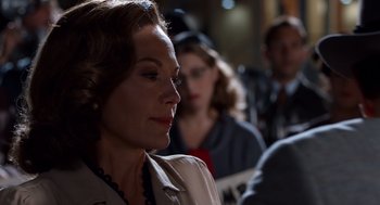 Movie still from “Trumbo” (2015), directed by Jay Roach – A person sitting in front of a group of people; Close Up shot, Over the shoulder angle