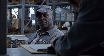 Movie still from “Trumbo” (2015), directed by Jay Roach – A man sitting at a table in a warehouse; Close Up shot, Over the shoulder angle