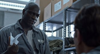 Movie still from “Trumbo” (2015), directed by Jay Roach – A man standing next to another man in a warehouse; Close Up shot, Over the shoulder angle