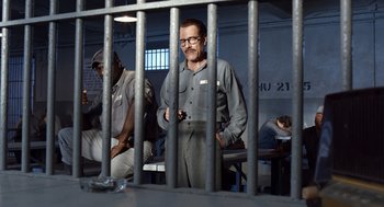 Movie still from “Trumbo” (2015), directed by Jay Roach – A man standing behind bars in a jail cell; Wide shot, Over the shoulder angle