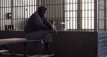 Movie still from “Trumbo” (2015), directed by Jay Roach – A man sitting on top of a bench in a jail cell; Medium shot, High angle