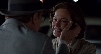 Movie still from “Trumbo” (2015), directed by Jay Roach – An older man touching the ear of a younger woman; Close Up shot, Over the shoulder angle