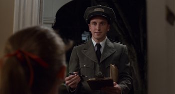 Movie still from “Trumbo” (2015), directed by Jay Roach – A man in a military uniform holding a book; Medium shot, Over the shoulder angle