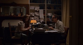 Movie still from “Trumbo” (2015), directed by Jay Roach – A man and a woman sitting at a desk; Medium shot, High angle